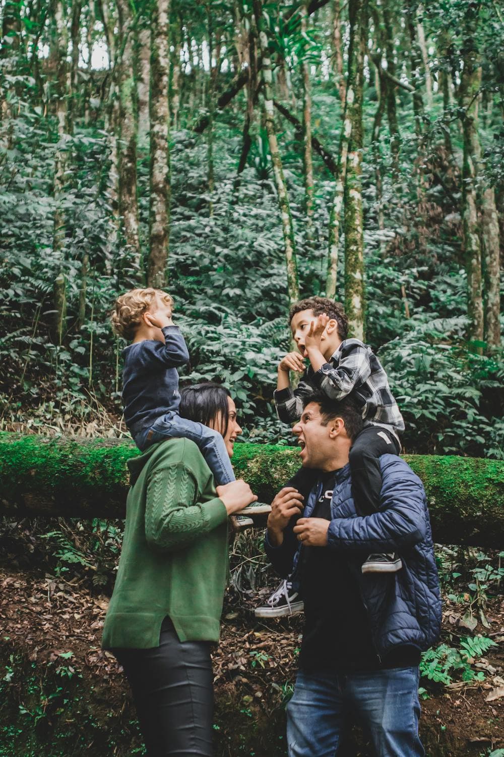 Parents walking with their children through a lush green forest on a sunny day