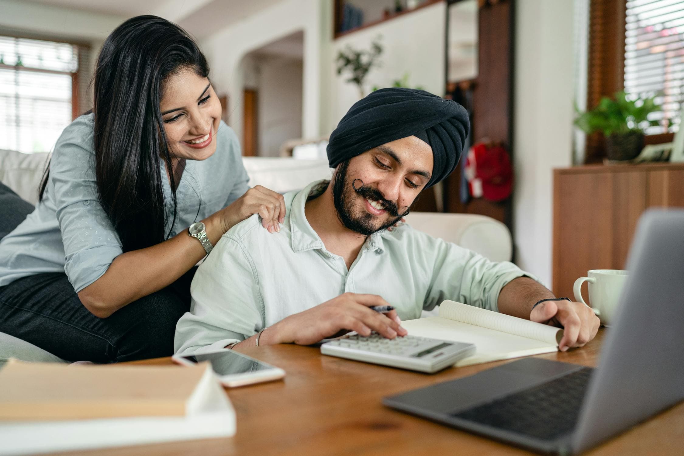 Parents reviewing summer camp costs and budget plans at their kitchen table